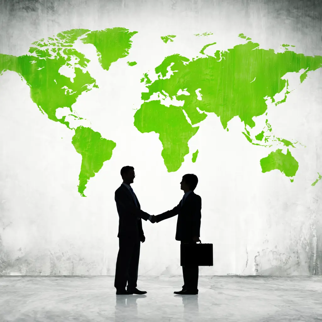 Business professionals shaking hands with a world map highlighting climate-focused policies.
